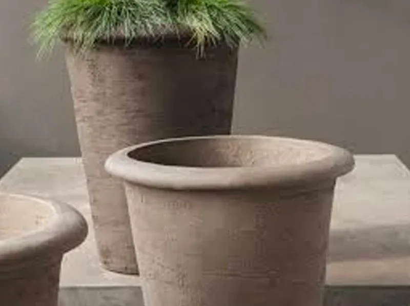 Grote grijze buitenpotten, beplant met siergras