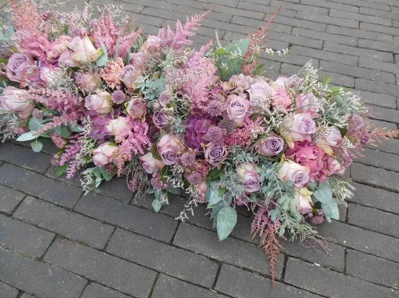 Kistbedekking van oudroze en lila rozen met astilbe