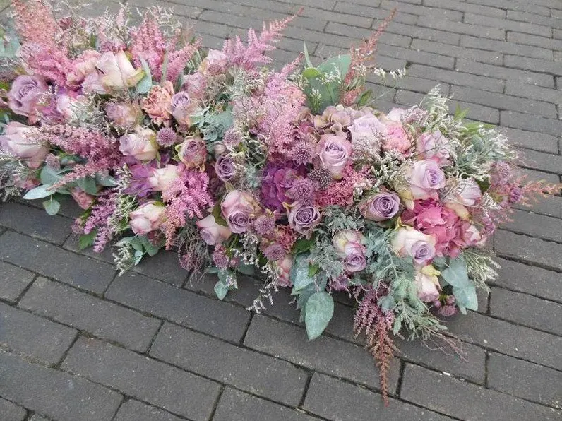 Kistbedekking van oudroze en lila rozen met astilbe