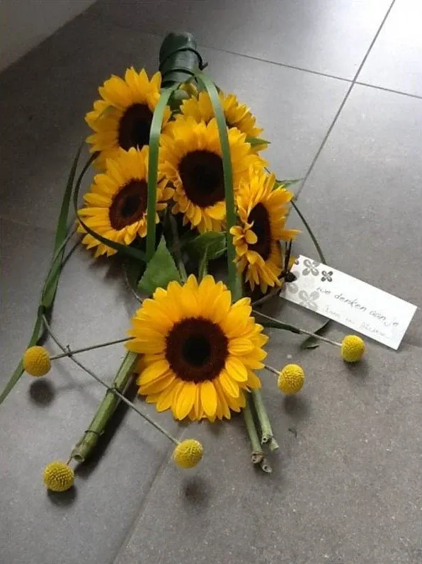 Rouwboeket van zonnebloemen en craspedia