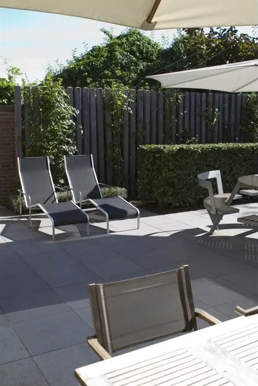Twee ligzetels op een terras met grote grijze tegels